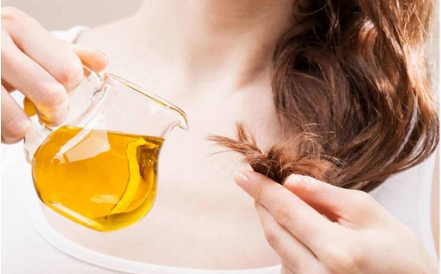 Mulher aplicando óleo no cabelo